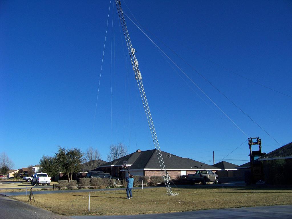 2009-03-30 Kodak 080.jpg - Taking Tower down Jan 2009. We thought it would work this way. It didn't. A 1/2" rope goes over to a pulley on a large forklift, over to pulley on trailer hitch of Chevy, then out to street to my Pickup. We thought we could move the pickup forward slowly and ease the tower down. The rope stretched at least 50'.